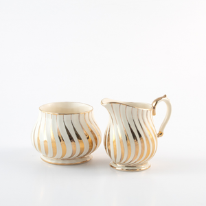 ivory coloured sugar bowl and creamer with gold stripes