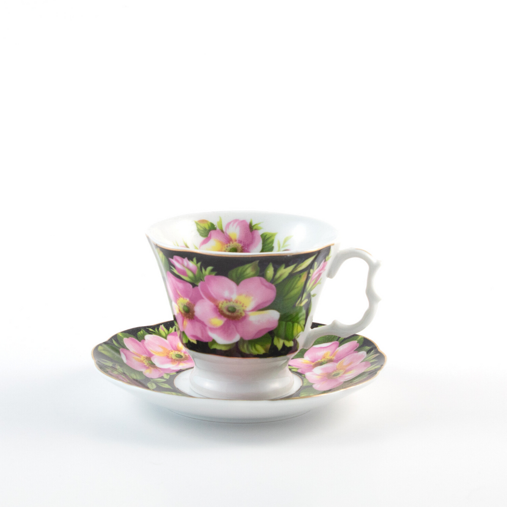 black teacup and saucer with pink flowers