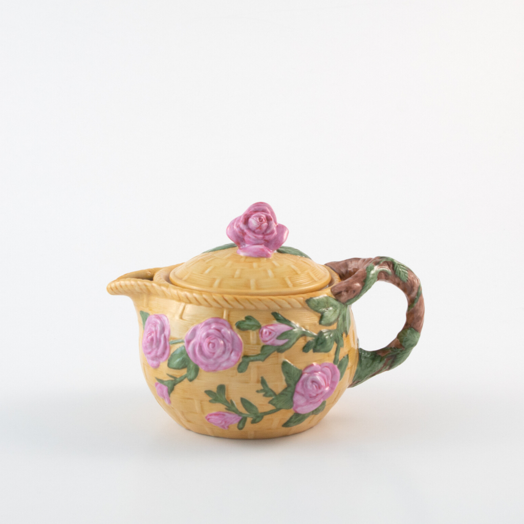 small yellow teapot with raised pink roses and green leaves on it